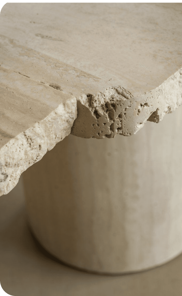 Detail of a natural travertine table – Irregular edge and mineral texture highlighting raw craftsmanship.
