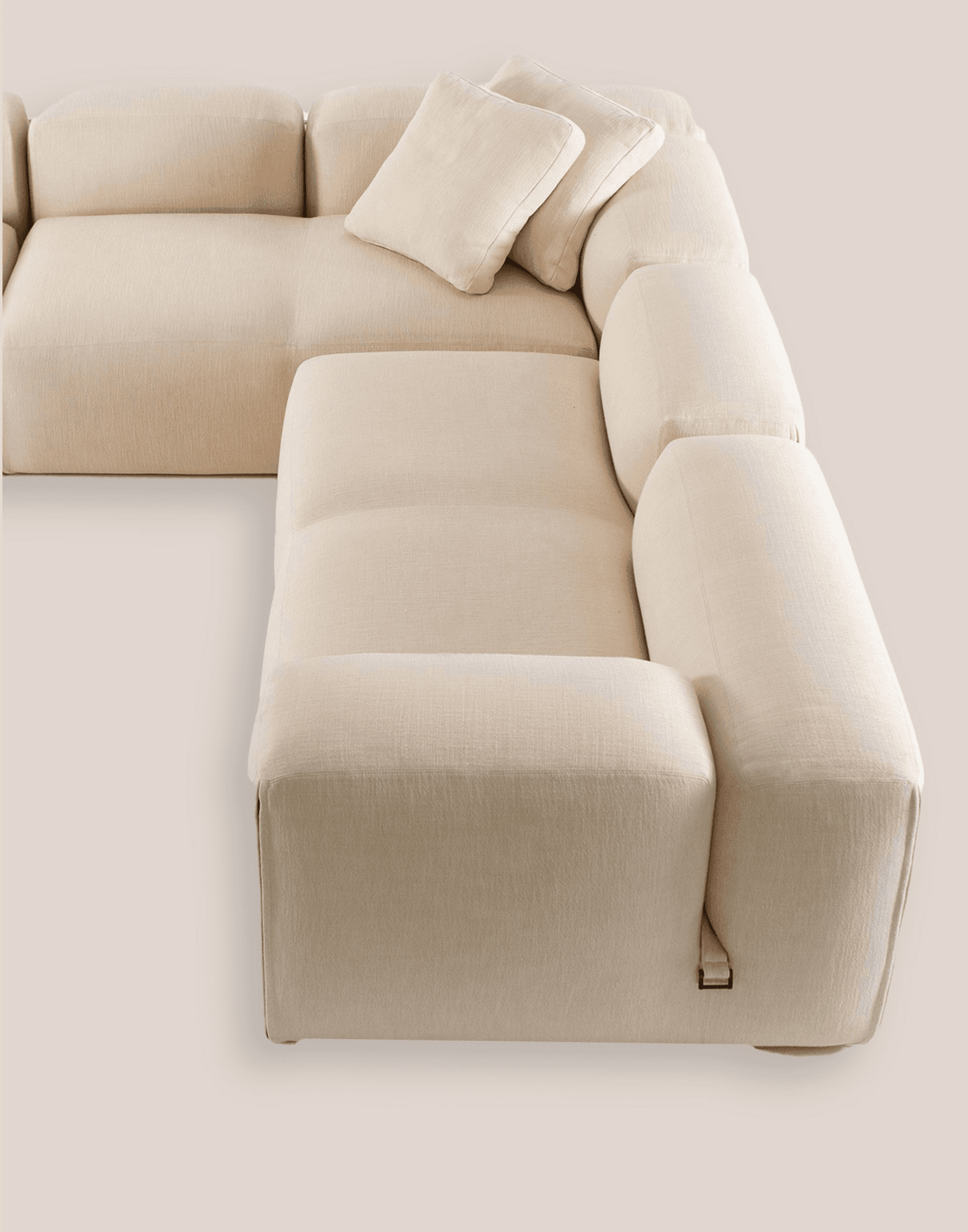 Contemporary modular sofa in taupe fabric with clean lines and low proportions, minimalist design on neutral background.