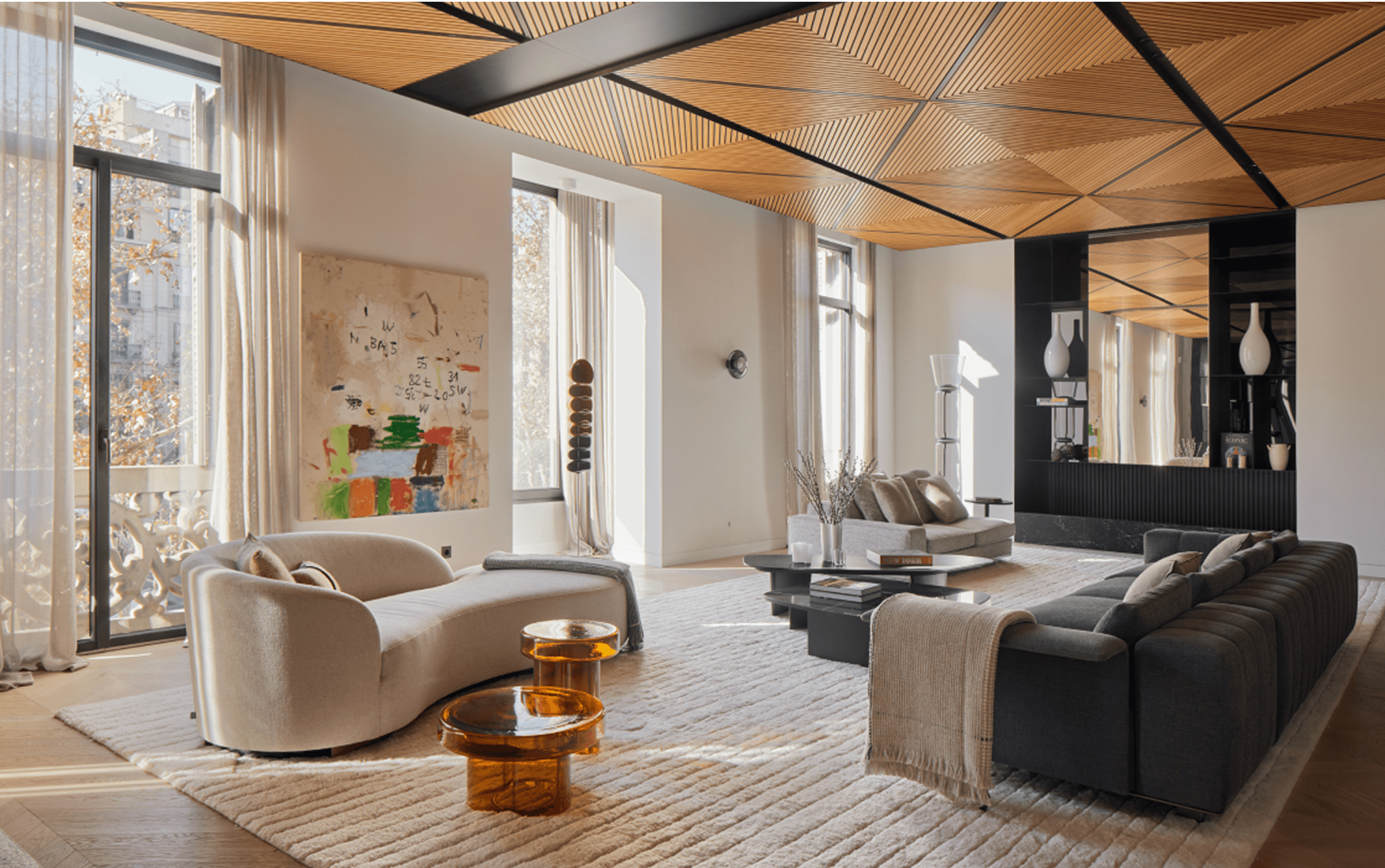 Spacious living room with wood ceiling, neutral sofas, abstract painting, and amber glass tables in a modern elegant design.
