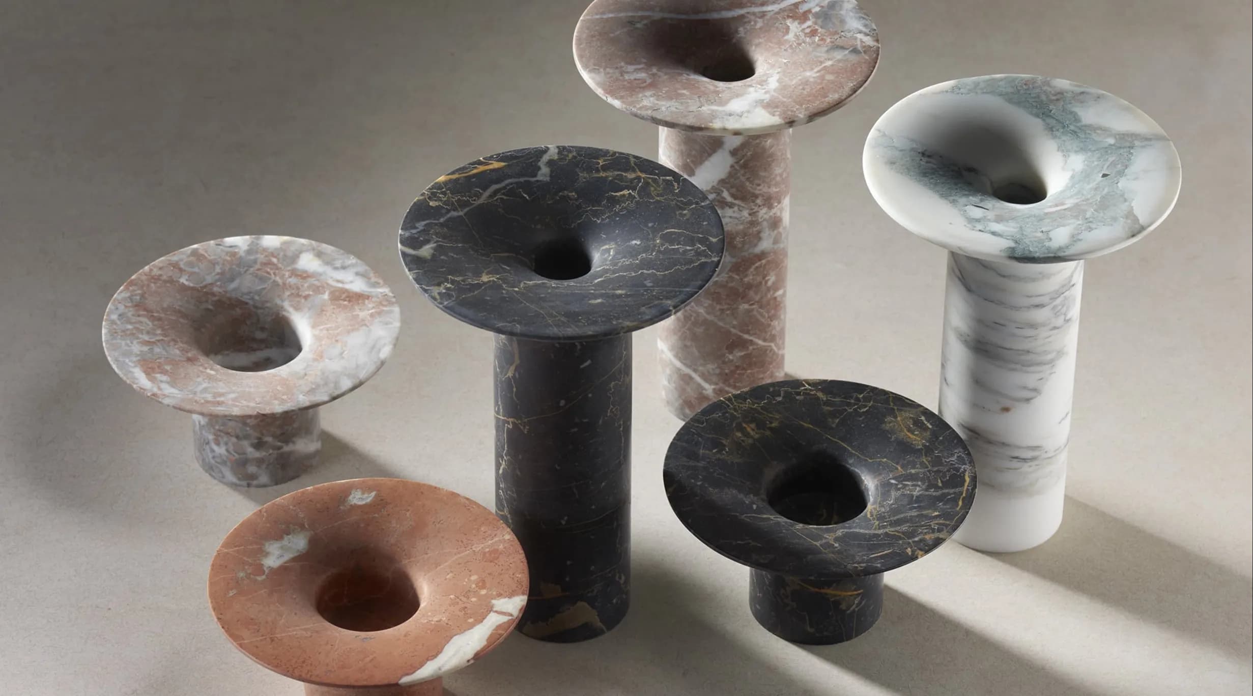 Assorted marble vases in different colors and heights with sculpted openings