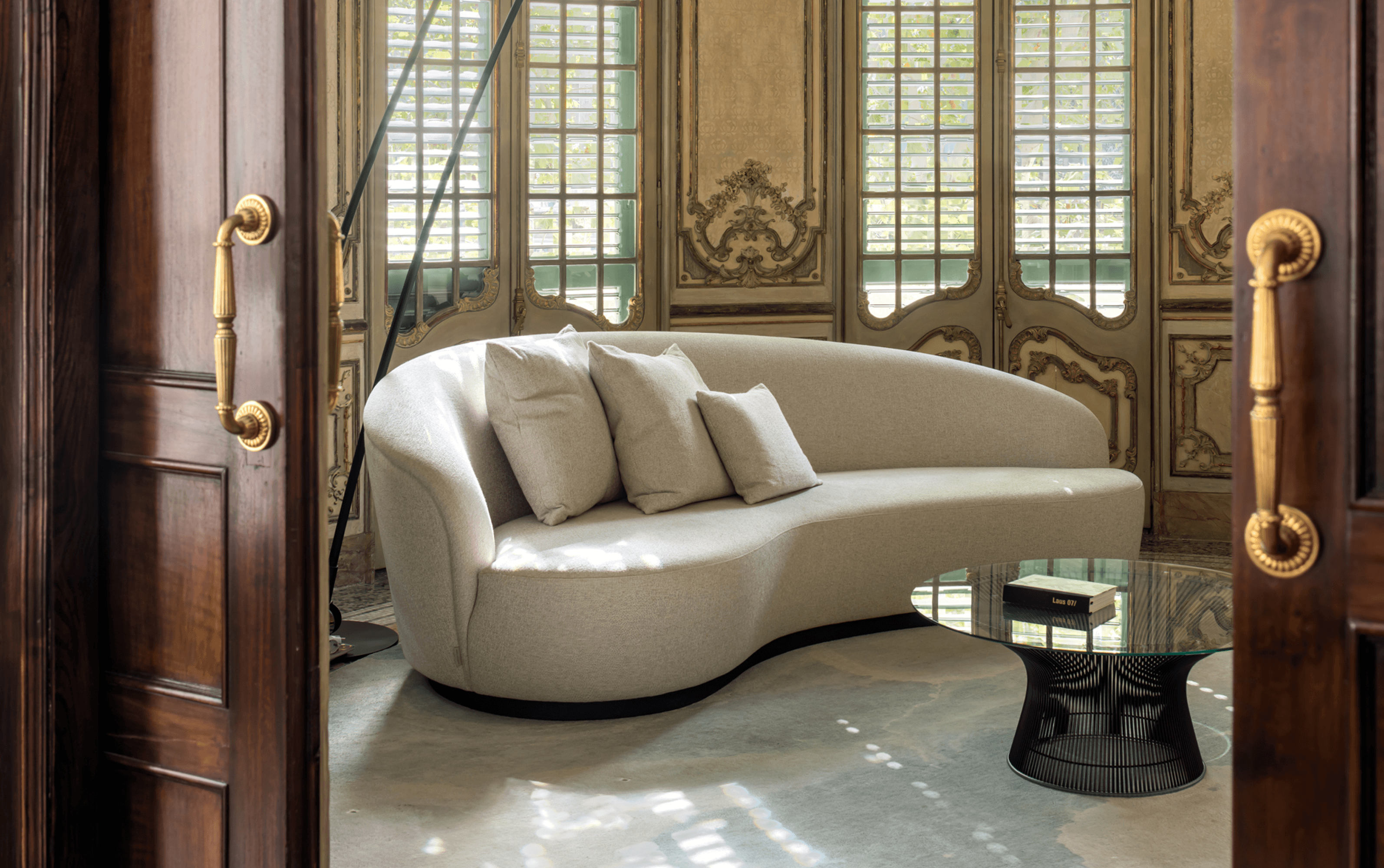 Curved beige sofa in a refined interior with decorative details · LUV Lifestyle FF&E