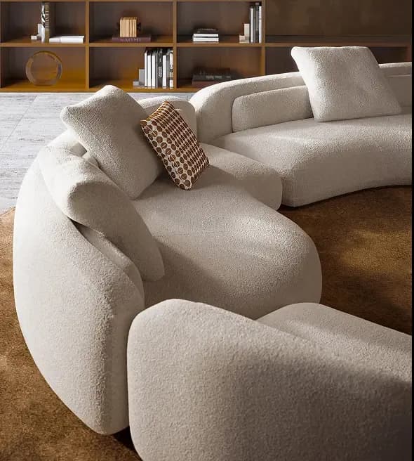 Curved modular sofa in cream bouclé with sculptural lines